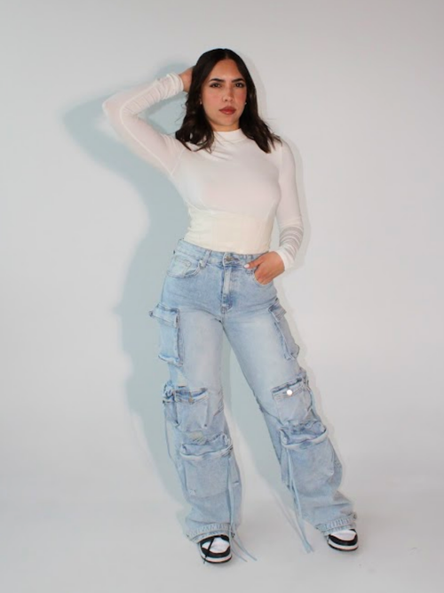 Model wearing light wash distressed cargo jeans with multiple pockets and edgy streetwear look, front view – ZADE FASHION