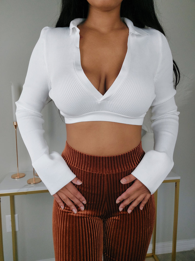 White v-neck crop top with collar and cuff sleeves. Rib Corduroy brown pants. White V-neck crop top with long sleeves and cuffed ends